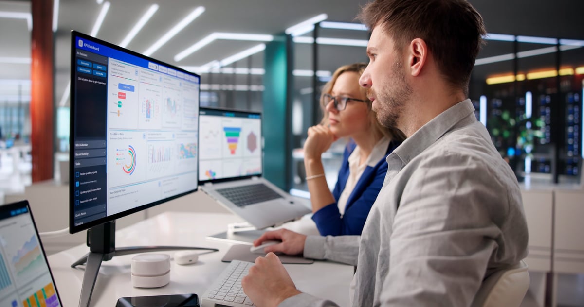 Business professionals analyzing KPI dashboards on a laptop for strategic decision-making